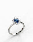 טבעת Diana מזהב לבן בשיבוץ אבן ספיר כחולה מרכזית והילת יהלומי צד